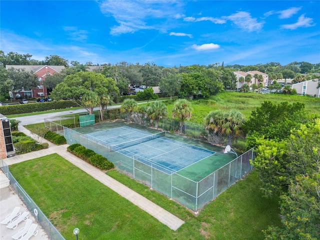 view of tennis court featuring a yard