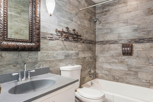 full bathroom featuring tiled shower / bath, vanity, and toilet