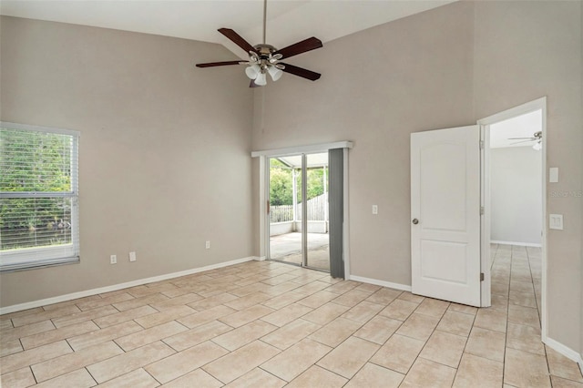 tiled spare room featuring high vaulted ceiling and ceiling fan