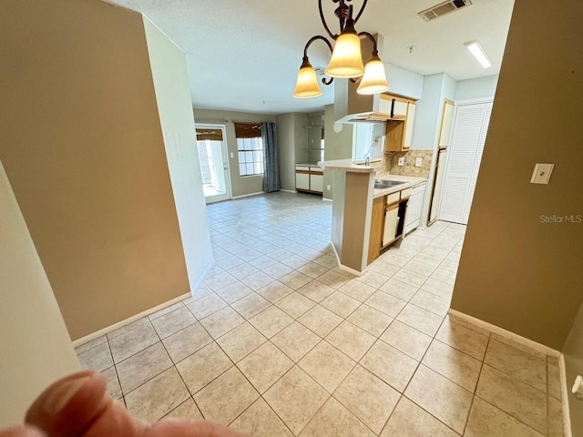 kitchen featuring backsplash, a notable chandelier, hanging light fixtures, and light tile patterned floors