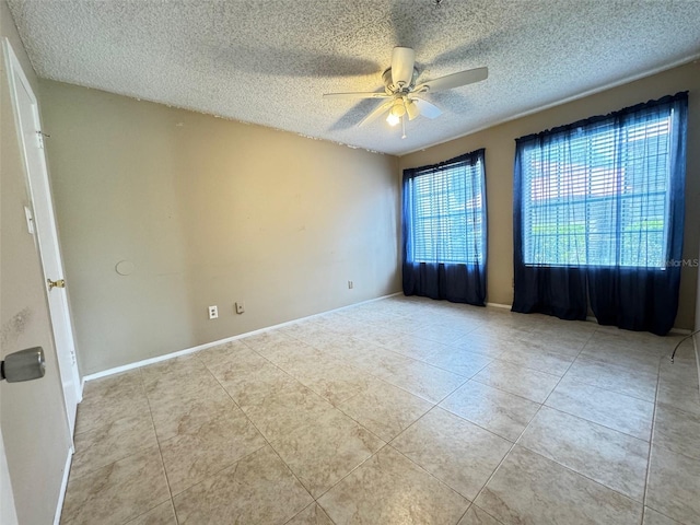 tiled spare room with a textured ceiling and ceiling fan