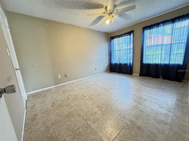 tiled spare room with a textured ceiling and ceiling fan