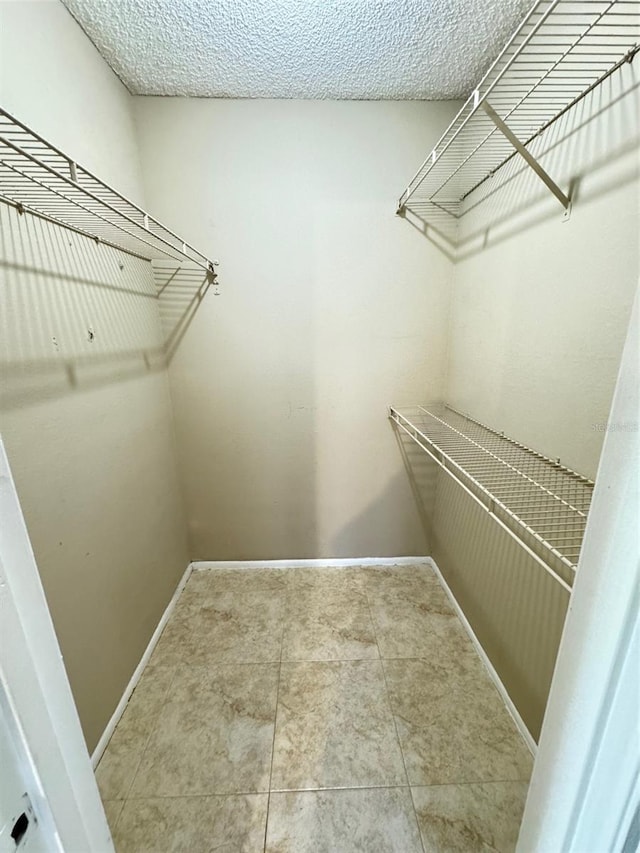 walk in closet with tile patterned floors