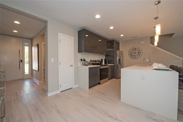 kitchen featuring pendant lighting, gray cabinets, appliances with stainless steel finishes, light wood-type flooring, and sink