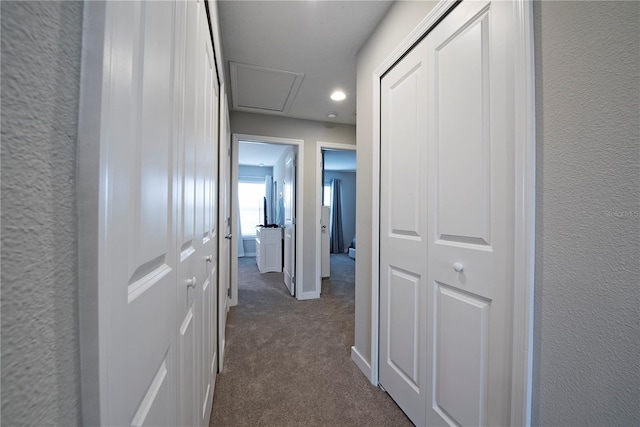 corridor featuring dark colored carpet