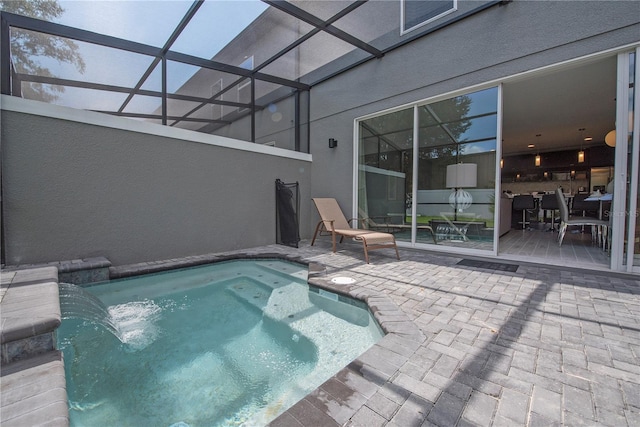 view of swimming pool featuring pool water feature, a patio, and a lanai