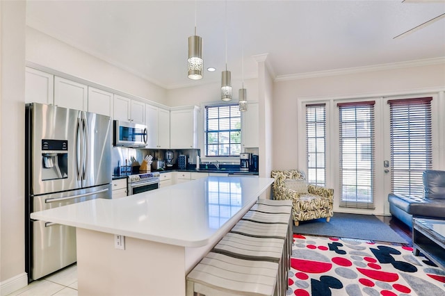 kitchen featuring a kitchen island, stainless steel appliances, a breakfast bar area, and white cabinetry