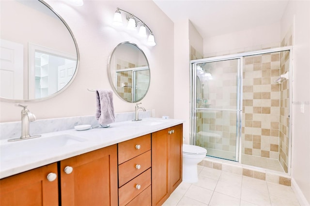 bathroom featuring toilet, a shower with door, vanity, and tile patterned flooring