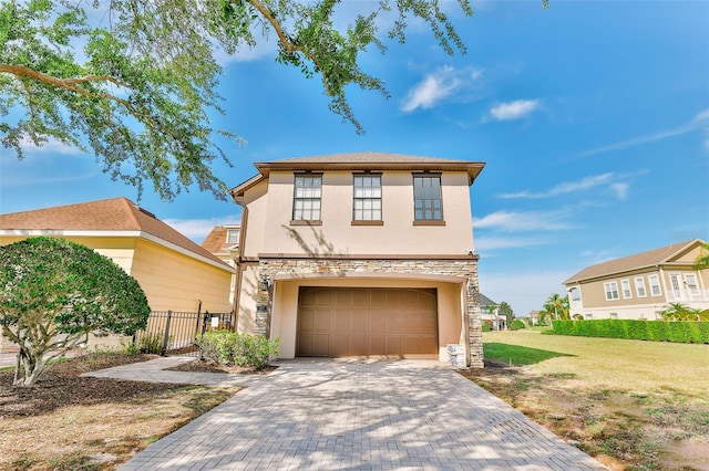 view of front of home featuring decorative driveway, stucco siding, an attached garage, fence, and stone siding