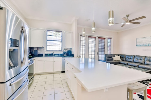 kitchen featuring decorative light fixtures, white cabinetry, a center island, light tile patterned floors, and appliances with stainless steel finishes