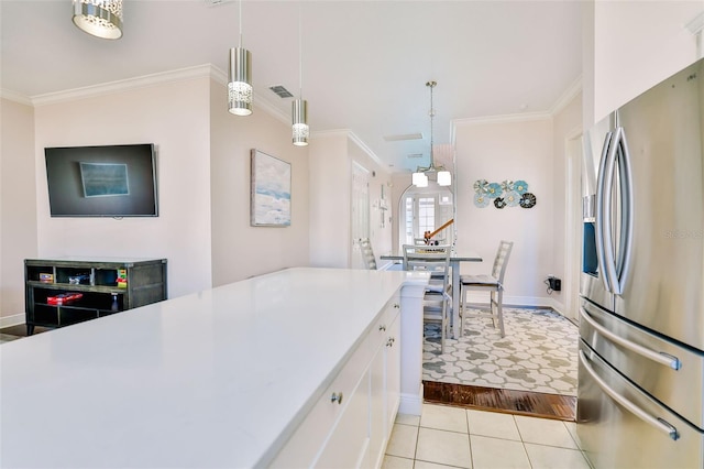 kitchen with ornamental molding, stainless steel refrigerator with ice dispenser, white cabinetry, decorative light fixtures, and light tile patterned flooring