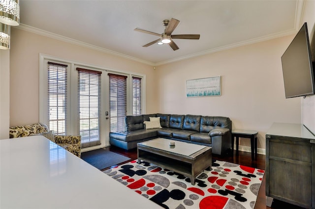 living room with dark wood-type flooring, ceiling fan, crown molding, and a healthy amount of sunlight