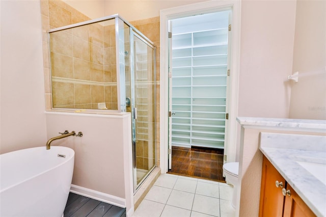 full bathroom with toilet, tile patterned floors, independent shower and bath, and vanity