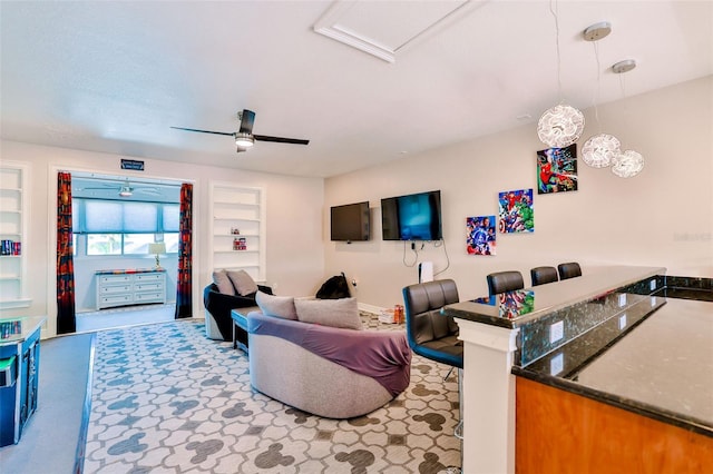 living room featuring ceiling fan and built in features