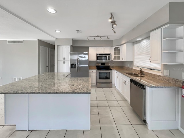 kitchen with dark stone counters, white cabinetry, appliances with stainless steel finishes, and sink