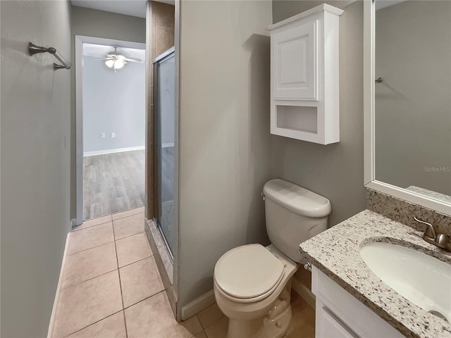 bathroom with tile patterned flooring, walk in shower, vanity, and toilet