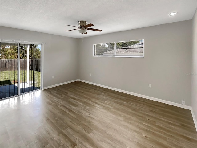 spare room featuring ceiling fan, a textured ceiling, plenty of natural light, and dark hardwood / wood-style flooring