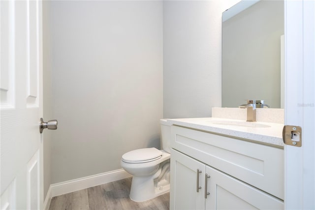 bathroom featuring toilet, hardwood / wood-style flooring, and vanity