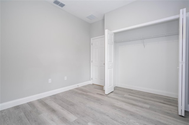 unfurnished bedroom with a closet and light hardwood / wood-style floors