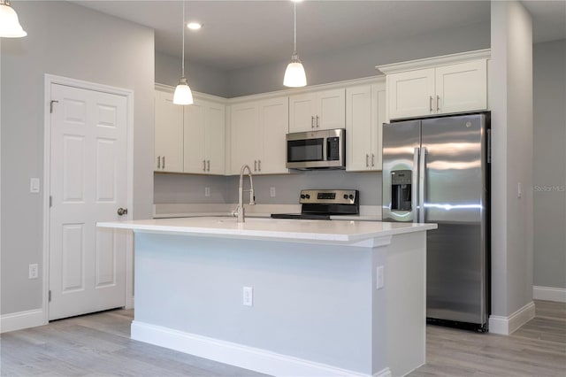 kitchen with a kitchen island with sink, light hardwood / wood-style floors, and stainless steel appliances