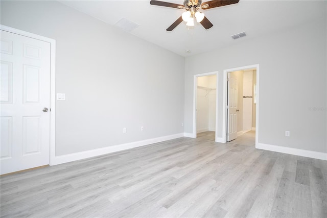 empty room with ceiling fan and light hardwood / wood-style flooring