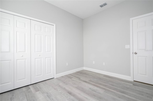 unfurnished bedroom featuring light wood-type flooring and a closet