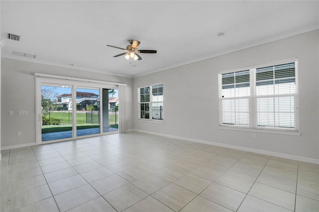 empty room featuring light tile floors, ceiling fan, and ornamental molding