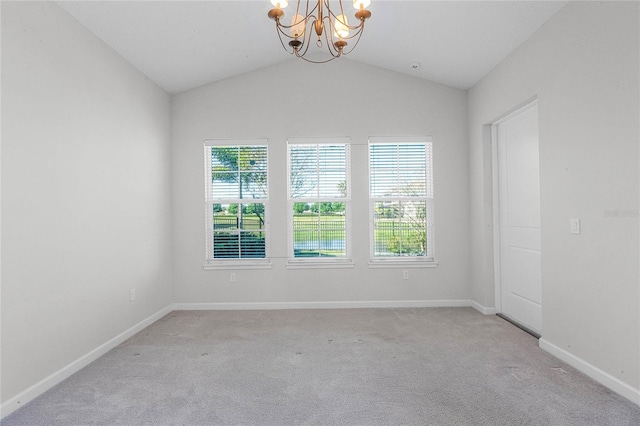 spare room featuring a chandelier, vaulted ceiling, and light carpet