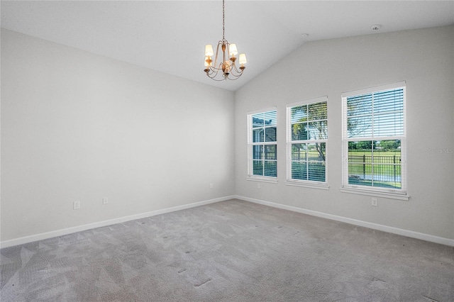 empty room with light carpet, an inviting chandelier, and vaulted ceiling