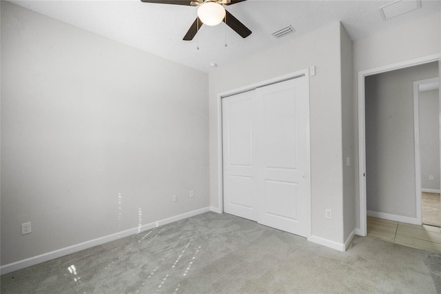 unfurnished bedroom with light tile floors, a closet, and ceiling fan