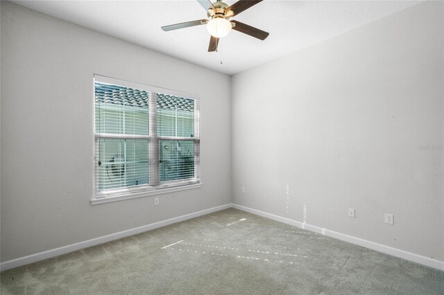 spare room featuring ceiling fan and light colored carpet