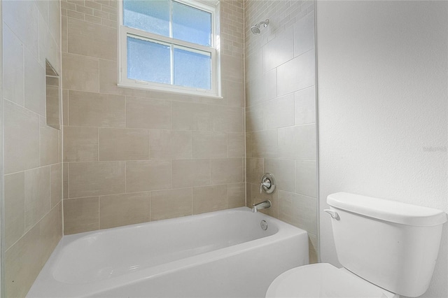 bathroom featuring toilet and tiled shower / bath