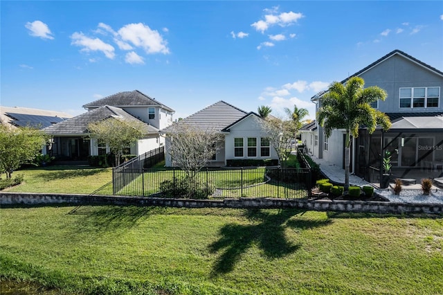 rear view of property with solar panels and a yard