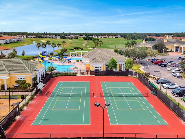 view of sport court with a water view and a community pool