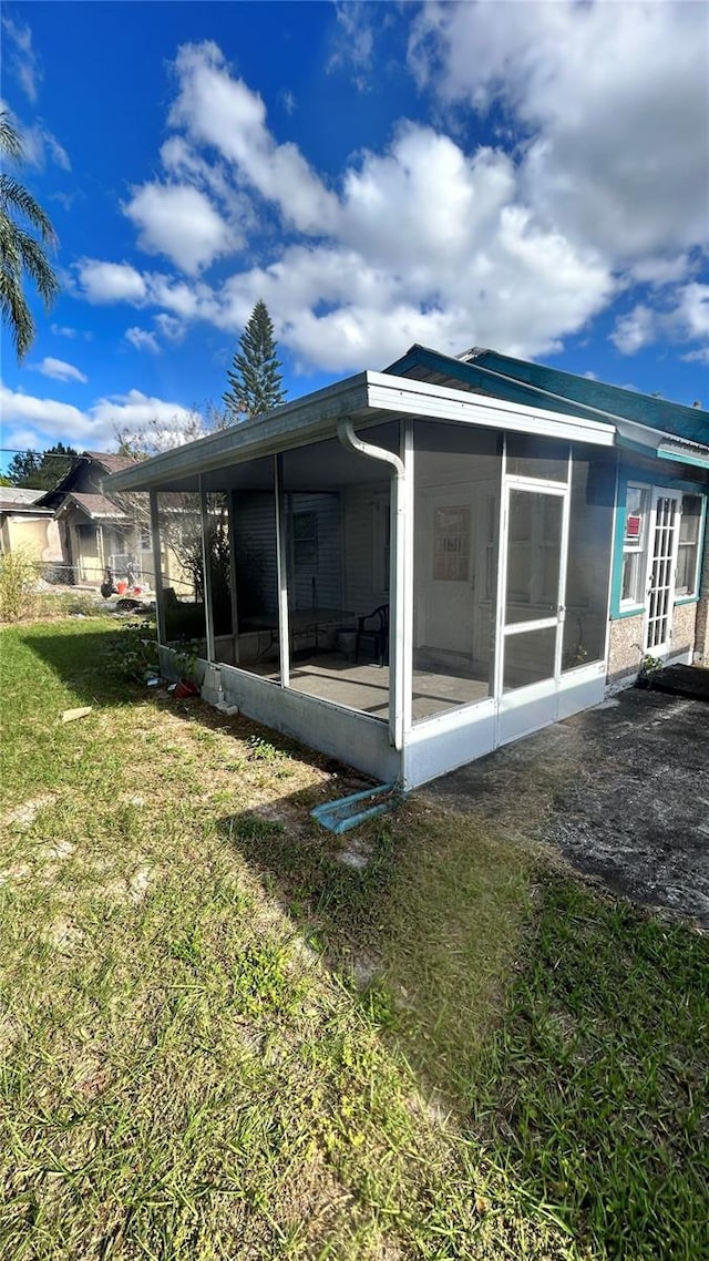 back of house with a sunroom and a yard