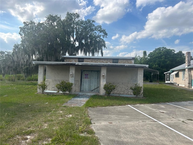 view of front of property with a carport and a front yard