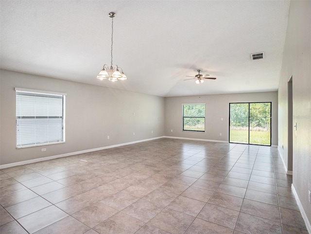 spare room featuring ceiling fan with notable chandelier and light tile floors