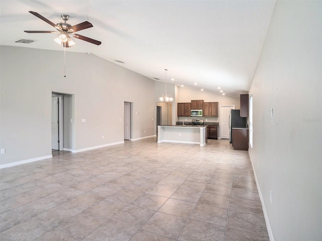 unfurnished living room with ceiling fan with notable chandelier, high vaulted ceiling, and light tile floors