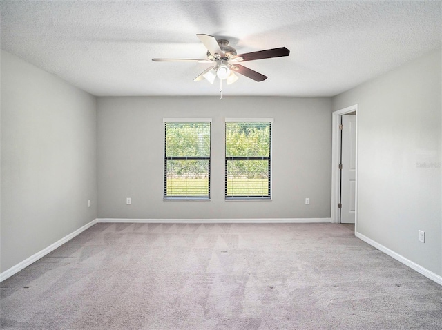 empty room with light colored carpet, a textured ceiling, and ceiling fan