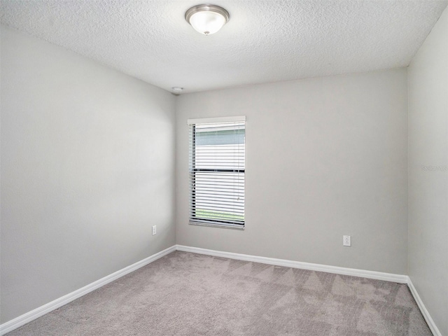 carpeted spare room with a textured ceiling