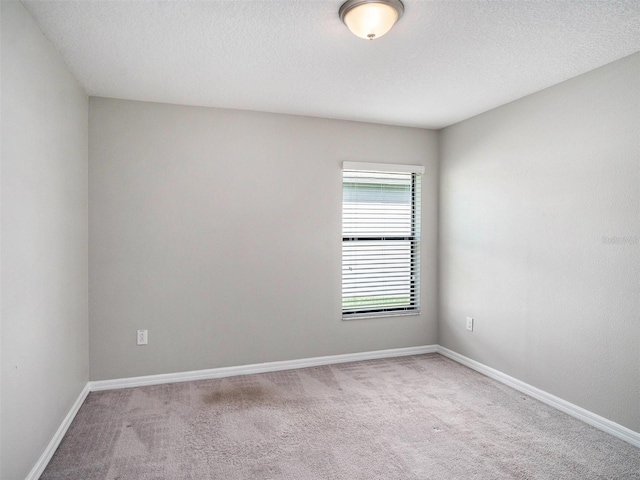 carpeted spare room with a textured ceiling