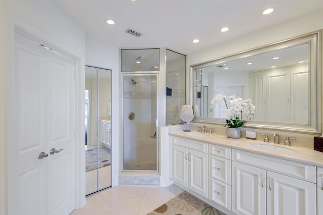 bathroom with walk in shower, double sink, oversized vanity, and tile flooring