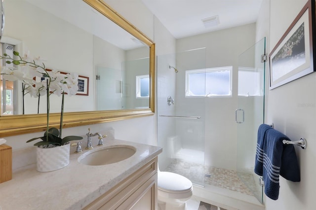 bathroom featuring an enclosed shower, toilet, and vanity