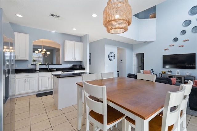 dining space with sink, a chandelier, and light tile flooring