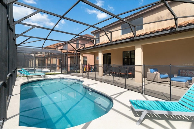 view of swimming pool featuring glass enclosure, a patio, and a hot tub