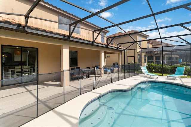 view of swimming pool with glass enclosure and a patio area