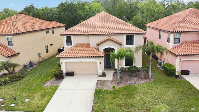 mediterranean / spanish home with a front lawn, a garage, and central AC unit