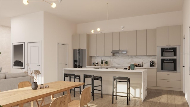 kitchen with double oven, stainless steel fridge with ice dispenser, a kitchen bar, sink, and gray cabinets