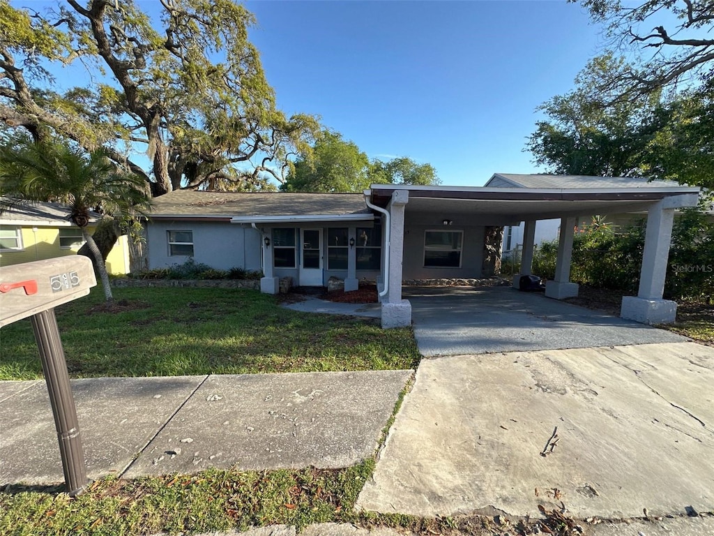 view of front facade featuring a carport and a front yard