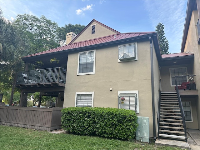 back of property with a lawn and a balcony